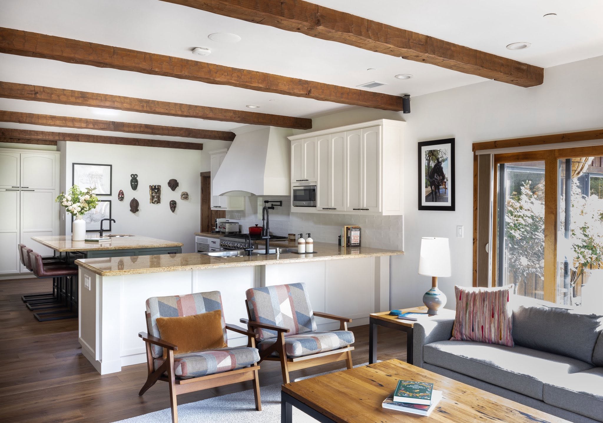 Warm open kitchen and living space with wood beams and natural light