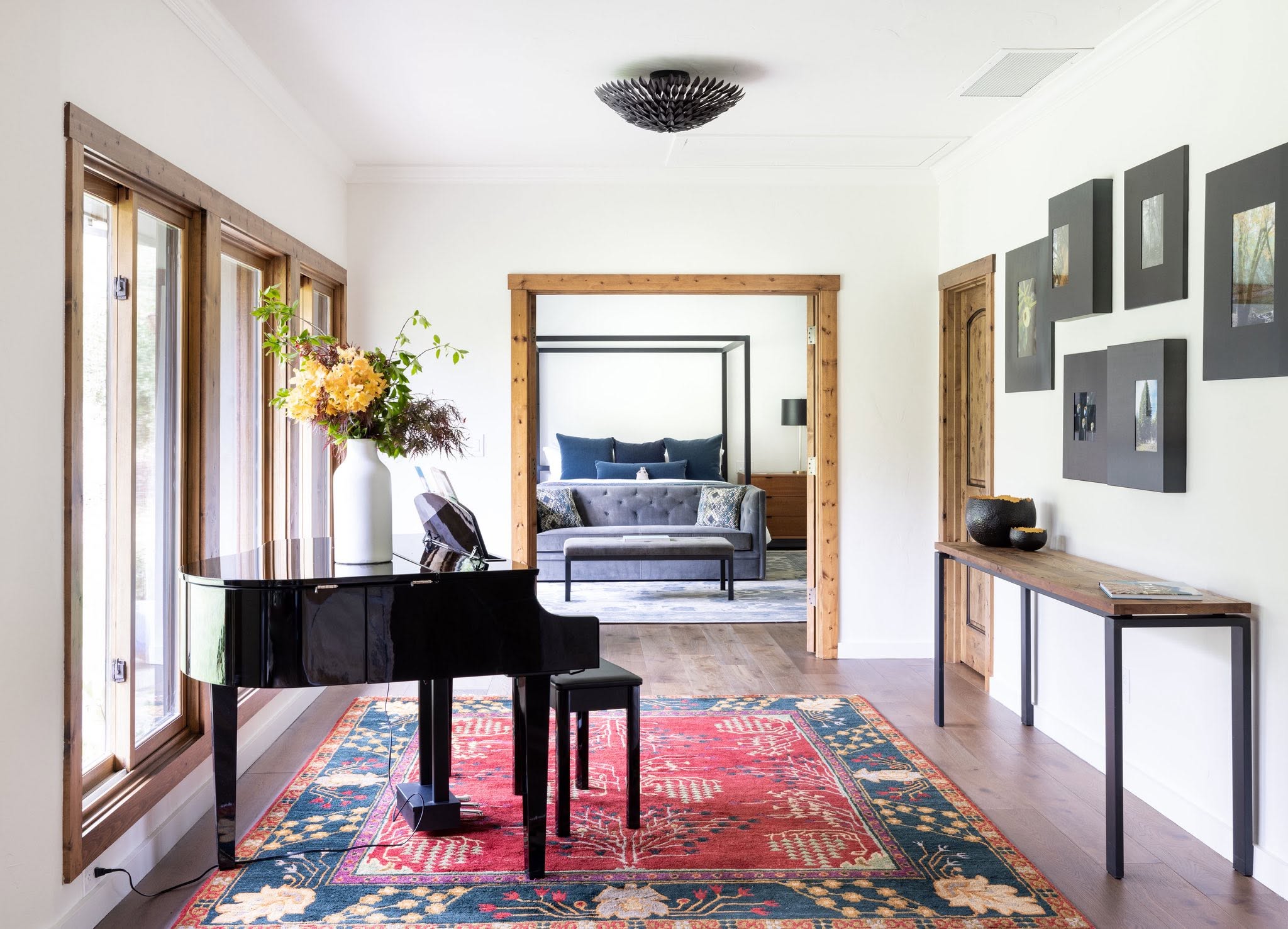 Living space with piano, gallery wall, and adjoining bedroom